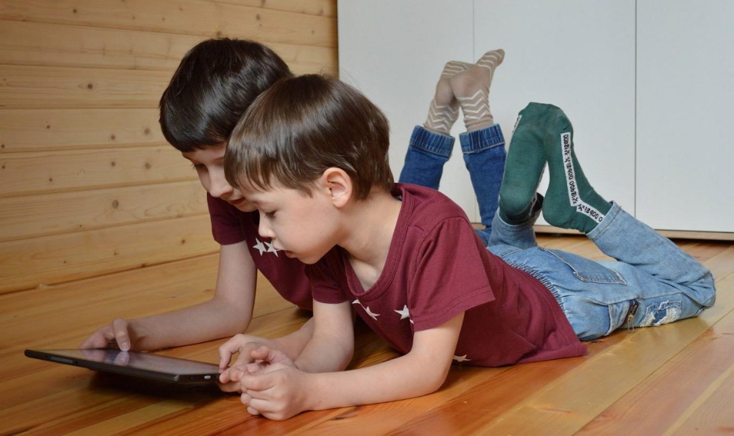 两个小孩在看平板电脑