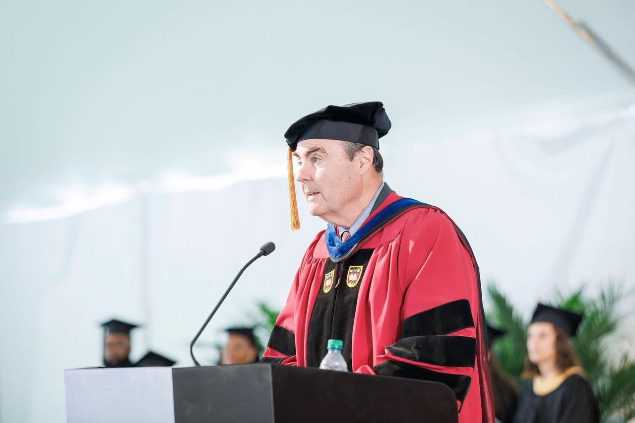 Tom Walsh, 戴帽子穿长袍, 在电子游戏软件社会工作学院2023年毕业典礼上发表讲话.
